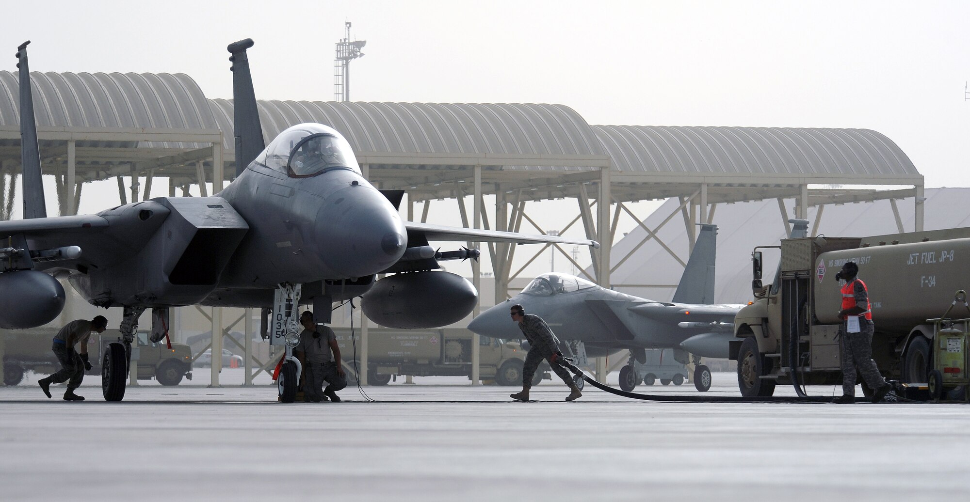 SOUTHWEST ASIA - Airmen at the 380th Air Expeditionary Wing refuel an F-15 Eagle between sorties using hot pits. Fuels specialists partner with weapons and maintenance experts to top off the tanks, all while the pilot keeps one of the engines running. The process means pilots can take to the air faster, saving maintainers the 90 minutes it would take to prepare another jet. (U.S. Air Force photo/Staff Sgt. J.G. Buzanowski)