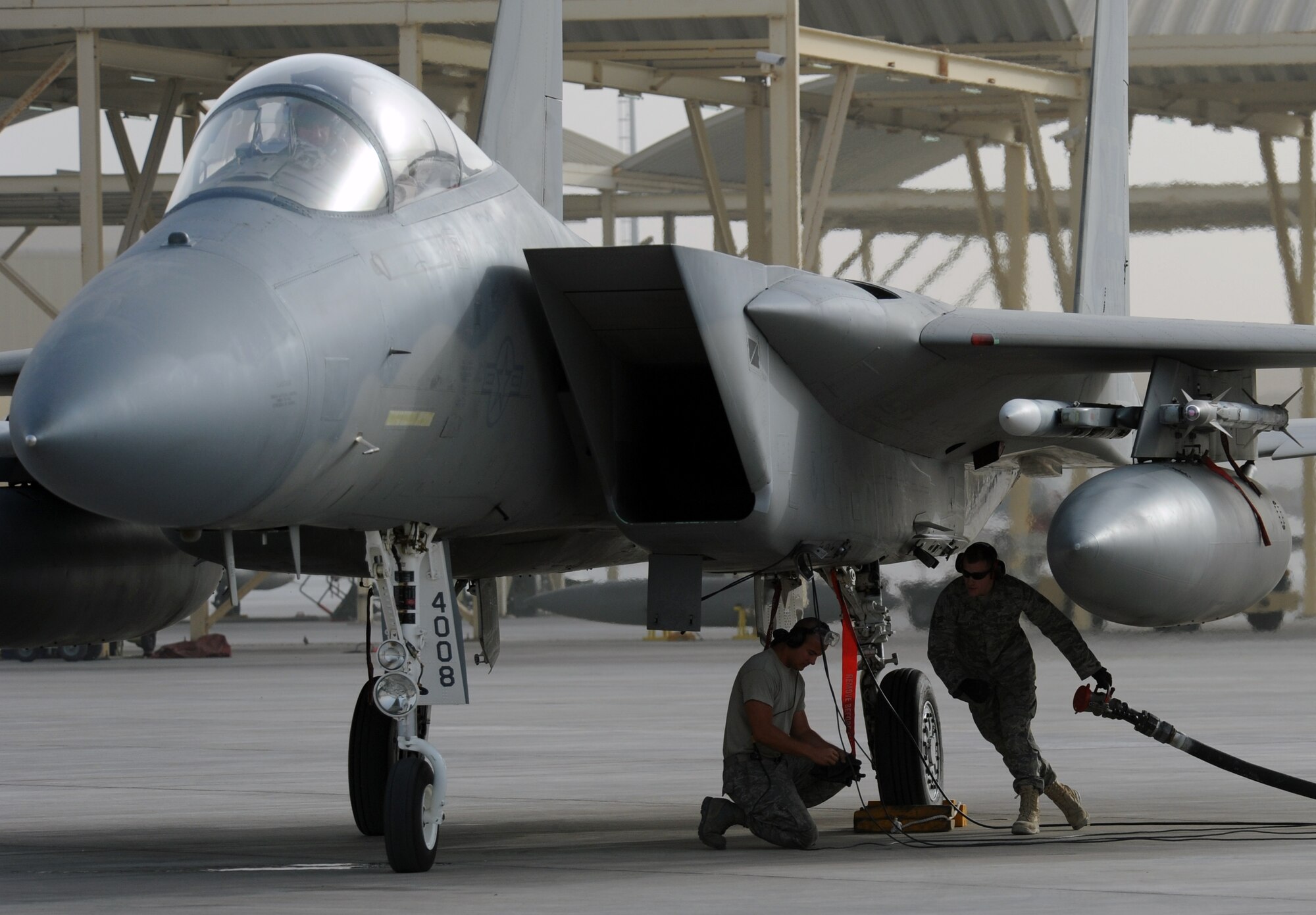 SOUTHWEST ASIA - Airmen at the 380th Air Expeditionary Wing refuel an F-15 Eagle between sorties using hot pits. Fuels specialists partner with weapons and maintenance experts to top off the tanks, all while the pilot keeps one of the engines running. The process means pilots can take to the air faster, saving maintainers the 90 minutes it would take to prepare another jet. (U.S. Air Force photo/Staff Sgt. J.G. Buzanowski)