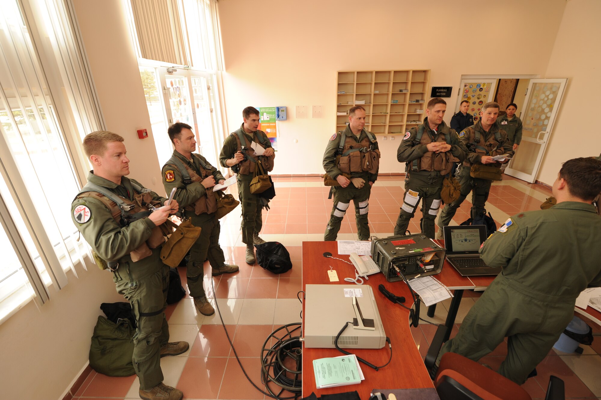 KONYA, Turkey – Pilots from the 480th Fighter Squadron listen during a preflight brief at the operations desk during Exercise Anatolian Falcon 2012. The briefing provides pilots with importing information such as weather, rules of engagement and taxiing procedures before leaving for the mission. (U.S. Air Force photo/Staff Sgt. Benjamin Wilson)