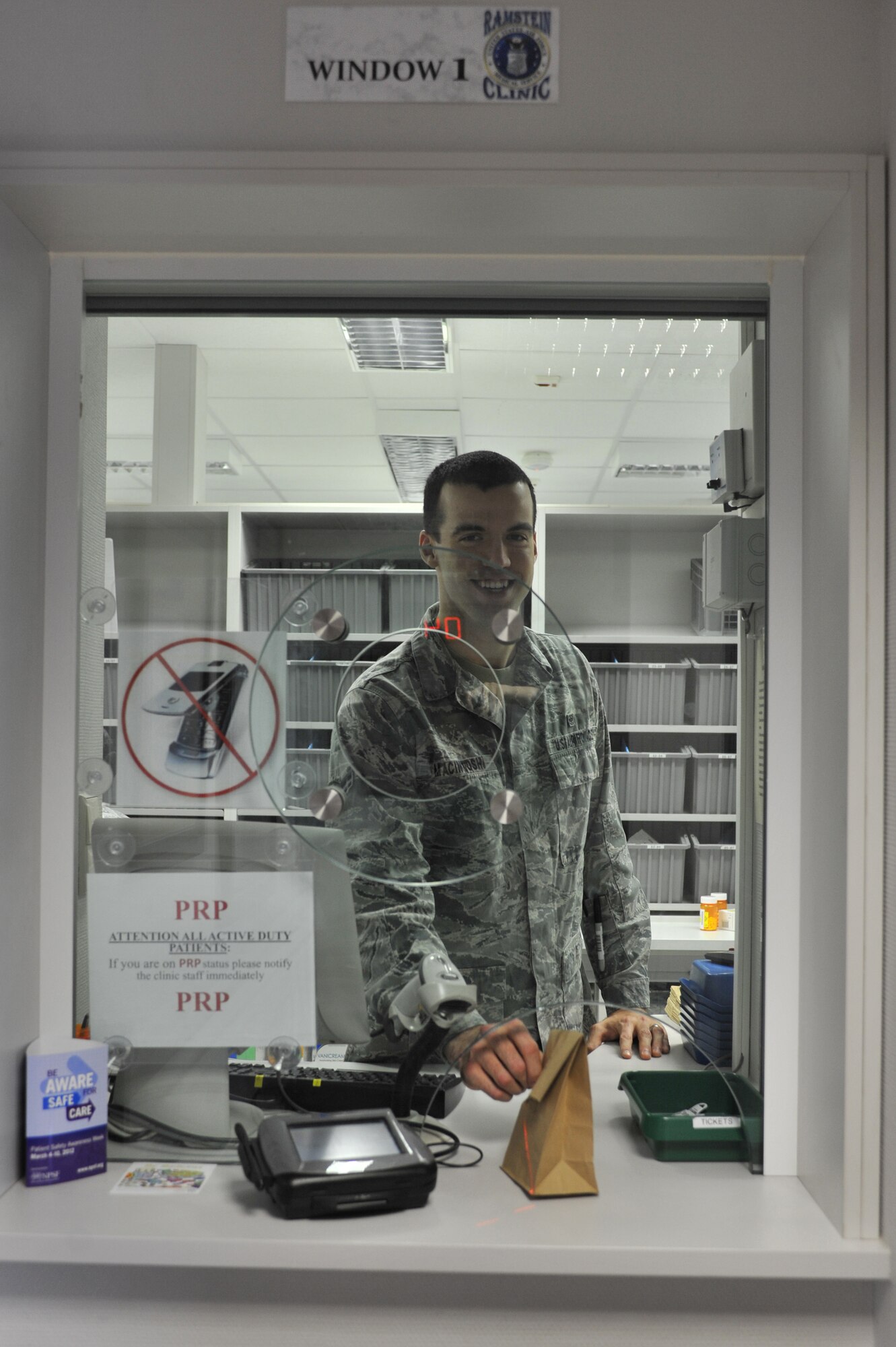 U.S. Air Force Airman 1st Class Michael Macintosh, 86th Medical Group pharmacy technician, delivers a completed prescription to a pharmacy customer, Ramstein Air Base, Germany, March 6, 2012. The 86th Medical Group Pharmacy fills 400 prescriptions any normal duty day to include a variety of medication and requested special orders. (U.S. Air Force photo/Airman 1st Class Caitlin O'Neil-McKeown)
