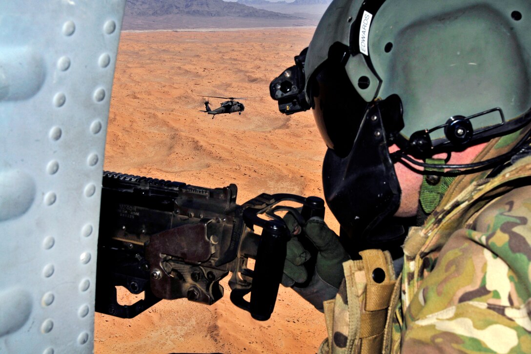 A U.S. Army crew chief mans a door gun as his UH-60 Black Hawk helicopter follows Mi-17 helicopters during a training air assault mission led by an Afghan air unit in Afghanistan's Kandahar province, Feb. 29, 2012. The crew chief is assigned to Company A, 2nd Battalion, 25th Aviation Regiment, 25th Combat Aviation Brigade.