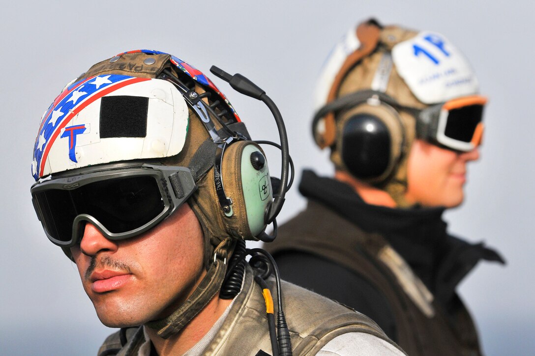 U.S. Navy Petty Officer 3rd Class Raymond Vigil, left, and Seaman Andrew Gonzalez work on the flight deck aboard the aircraft carrier USS Carl Vinson in the Arabian Gulf, March 5, 2012. Vigil, an aviation electronics technician, and Gonzalez, an aviation ordnanceman airman, are assigned to Strike Fighter Squadron 22.