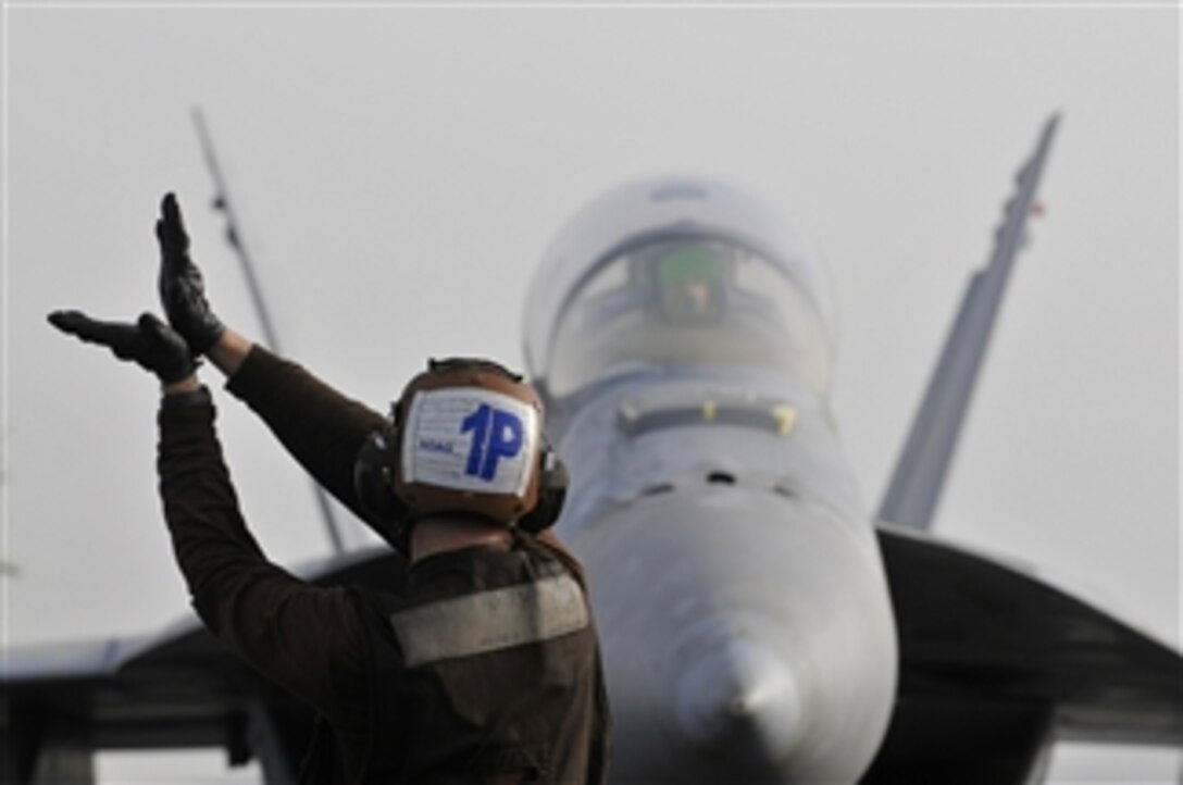U.S. Navy Airman Mackenzie Hoag, assigned to Strike Fighter Squadron 22, signals to the pilot of an F/A-18F Super Hornet aircraft aboard the aircraft carrier USS Carl Vinson (CVN 70) while underway in the Persian Gulf on March 5, 2012.  The Carl Vinson and Carrier Air Wing 17 are deployed to the U.S. 5th Fleet area of responsibility.  