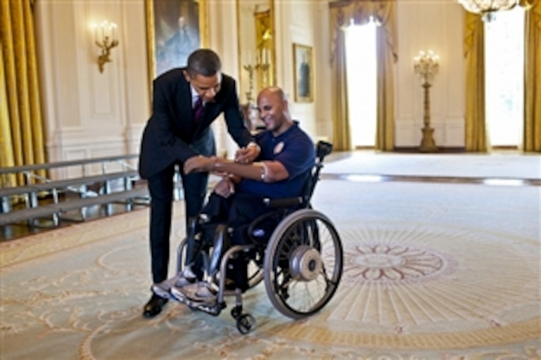 President Barack Obama signs the prosthetic arm of Marine Corps Sgt. Carlos Evans after greeting wounded warriors during their tour of the White House in Washington, D.C., March 6, 2012. First Lady Michelle Obama met Evans, who was injured in Afghanistan while on his fourth combat deployment, during a visit to Walter Reed Army Medical Center in 2010.