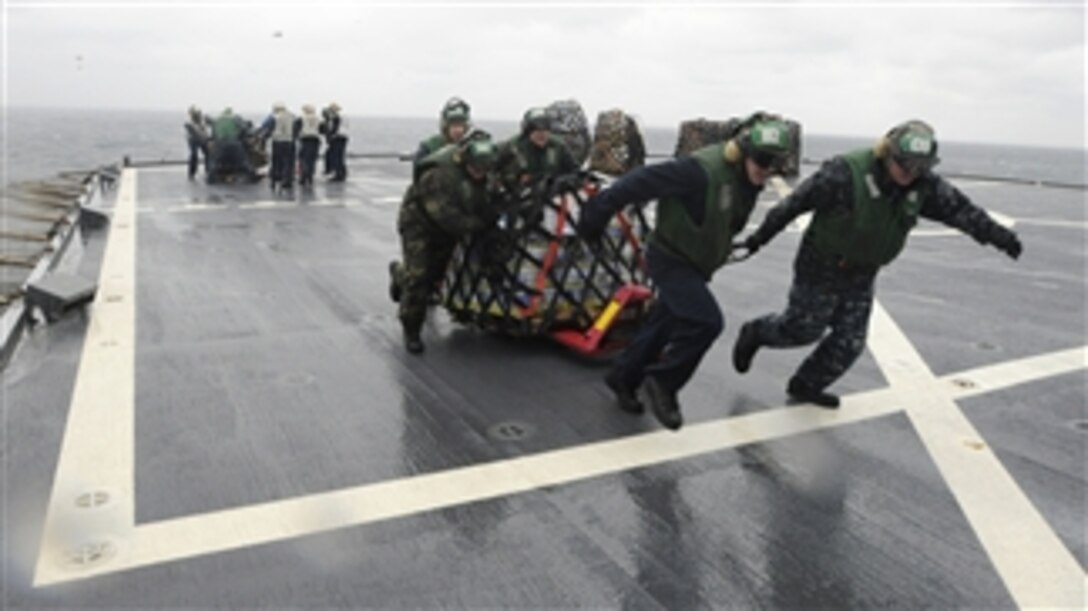 U.S. Navy sailors assigned to Helicopter Anti-Submarine Squadron Light 51 move pallets off the flight deck of the U.S. 7th Fleet command ship USS Blue Ridge (LCC 19) during a vertical replenishment in the Sea of Japan on March 5, 2012.  