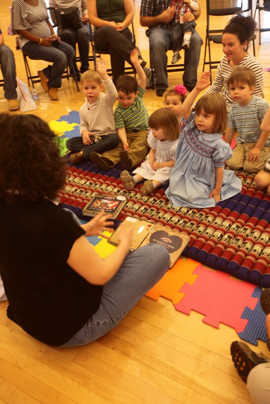 A group of children raises their hands when asked, “Who knows a Marine?” during a 2nd Marine Logistics Group family event at Marston Pavilion aboard Camp Lejeune, N.C., March 3, 2012. Crafts, lunch and story time rounded out the family fun day for kids ranging in age from one to 11 years. (U.S. Marine Corps photo by Cpl. Katherine M. Solano)