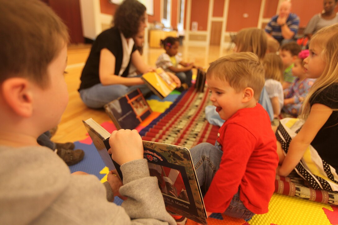 Children of 2nd Marine Logistics Group Marines enjoy story time with a book about what their “mommy and daddy Marines do” during a family fun event at Marston Pavilion aboard Camp Lejeune, N.C., March 3, 2012. The kids showed each other photos from the books and participated in the activities described in the story, such as saluting and marching. (U.S. Marine Corps photo by Cpl. Katherine M. Solano)