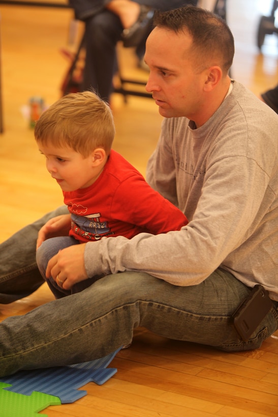 William Cooper and his father, Maj. Lee Cooper, a Marine with 2nd Marine Logistics Group, sit and listen to story time together during an event at Marston Pavilion aboard Camp Lejeune, N.C., March 3, 2012. William, an active two-year-old, was anxious to play with the other children as soon as the story was over, and the other kids were more than happy to oblige. (U.S. Marine Corps photo by Cpl. Katherine M. Solano)