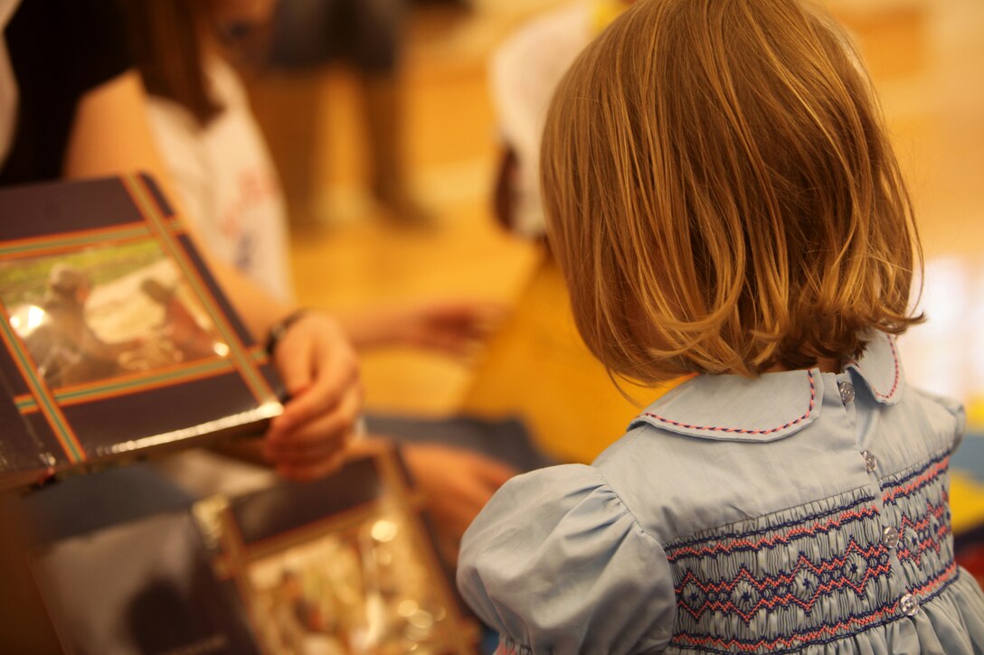 Kathryn Caola, a four-year-old daughter of a 2nd Marine Logistics Group Marine, looks at pictures in a story book during a family fun event at Marston Pavilion aboard Camp Lejeune, N.C., March 3, 2012. Kathryn and her younger sister started the day with crafts and coloring before settling down the with other children for story time and then lunch. (U.S. Marine Corps photo by Cpl. Katherine M. Solano)