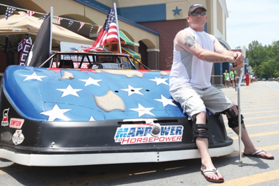 Former Staff Sgt. George Young, a wounded veteran, sits on the Manpower to Horsepower car outside the Wal-Mart located on Yopp Road in Jacksonville, N.C., June 25. Manpower to Horsepower is a nonprofit organization meeting the transitional needs of combat veterans.