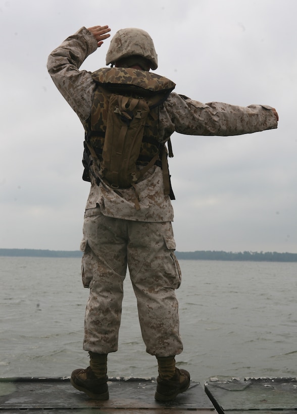 Staff Sgt. Andrew J. Brannen, a combat engineer with 8th Egineer Support Battalion, 2nd Marine Logistics Group, directs an Improved Float Bridge during an operation aboard Marine Corps Base Camp Lejeune July 14, 2011. The objective of the mission was to ferry 10 M1A1 Abrams Main Battle Tanks and one M88 Hercules Heavy Equipment Recovery Vehicle to the annual gunnery qualifications for 2nd Tank Battalion, 2nd Marine Division. (Marine Corps Photo by Pvt. Brian M. Woodruff)