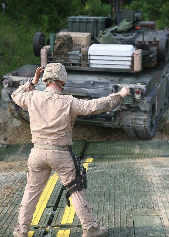 Lance Cpl. Zachary G. Mixon, a tank crewman with 2nd Tank Battalion, 2nd Marine Logistics Group, directs an M1A1 Abrams Main Battle Tank onto an Improved Float Bridge during an operation aboard Marine Corps Base Camp Lejeune July 14, 2011. The objective of the mission was to ferry 10 M1A1 tanks and one M88 Hercules Heavy Equipment Recovery Vehicle to the annual gunnery qualifications for 2nd Tank Battalion, 2nd Marine Division. (Marine Corps Photo by Pvt. Brian M. Woodruff)