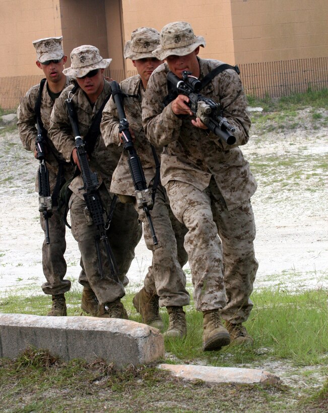 Cpl. Joseph Rhodes with 3rd platoon, Company F, Anti-Terrorism Battalion, attached to 2nd Marine Division, leads a fireteam into a simulated room during the Basic Urban Skills Training course at the Military Operations on Urban Terrain facility aboard Marine Corps Camp Lejeune, July 7, 2011. The BUST is a week-long course, covering a multitude of skills such as basic room clearing techniques, fireteam movement on urban terrain and techniques for patrolling through an urban setting.