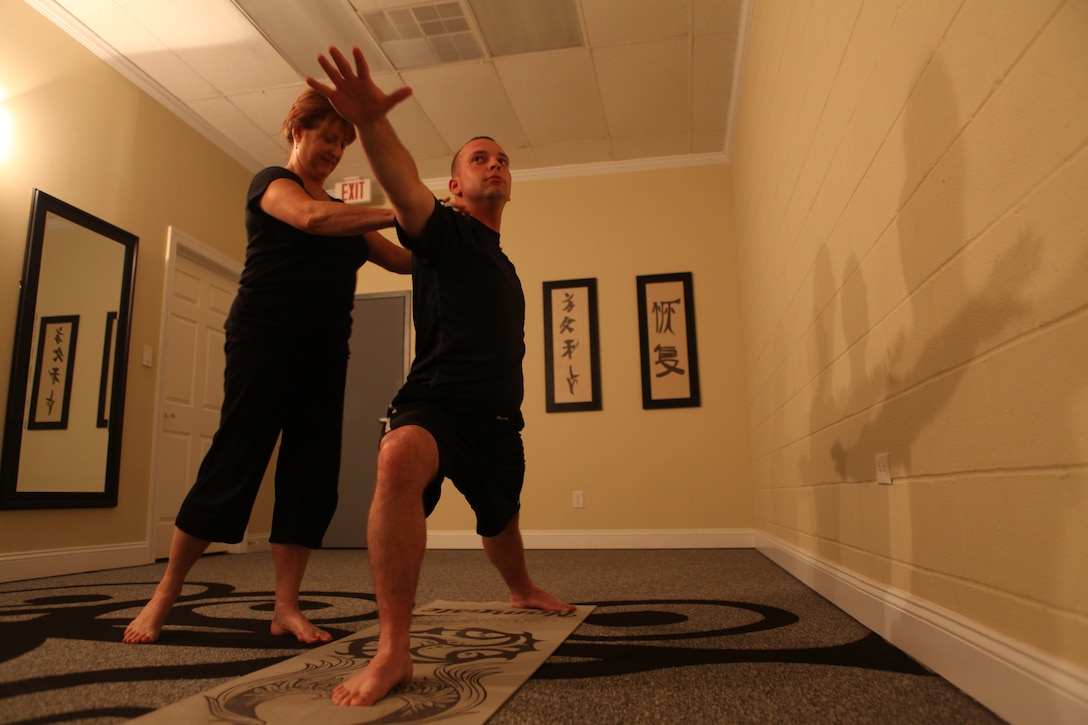 Cheryl LeClair watches Petty Officer 3rd Class Patrick Haslett conduct Yoga exercises at the Second Wind Eco Tours building in Swansboro, N.C., June 23. LeClair provides free yoga and Integrative Restoration, or iRest, therapy to active-duty service members and combat veterans every Thursday evening.