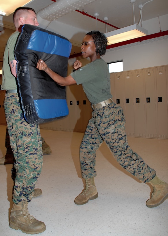 Lance Cpl. Whitney N. Borum, administrative specialist, Marine Corps Logistics Base Albany, drives a edged fist strike into a pad held by Sgt. Brian Fitzgerald, military police officer, Marine Corps Police Department, recently.