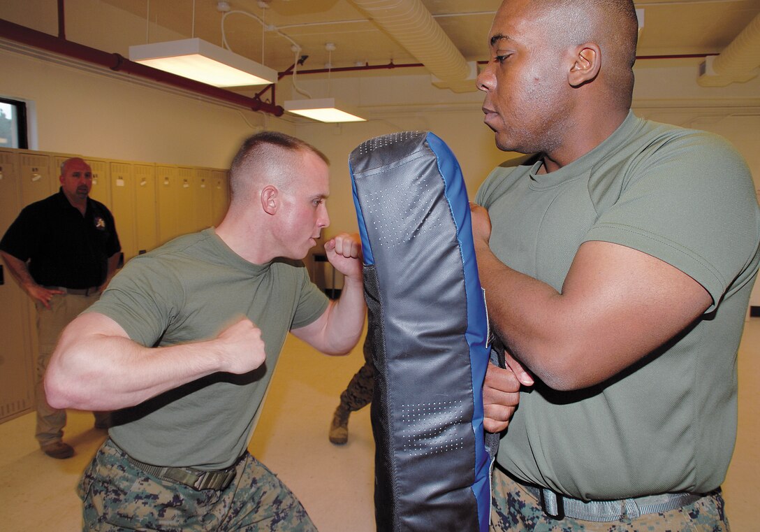 Cpl. Martin Lavigne, left, military police officer, Marine Corps Police Department, drives an elbow strike into the pad of Cpl. Sheldrick Thomas, motor transportation operator, licencing office, Garrison Mobile Equipment, Logistics Support Division, Marine Corps Logistics Base?Albany.