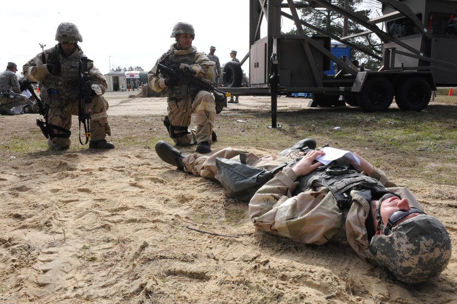 U.S. Air Force Staff Sgt. Michael Marez acts as a casualty while Master Sgt. Albert Branch calls for medical assistance and Tech. Sgt. Khalil Sewell provides overwatch during a phase II Operational Readiness Exercise on Seymour Johnson Air Force Base, N.C., Mar. 8, 2012. The exercise uses simulated conditions to evaluate the wing's ability to deploy at a moment's notice. Marez, Branch and Sewell are members of the 4th Security Forces Squadron. Marez hails from Riverside, Calif., Branch is from Panama City, Fla., and Sewell is originally from Frankfort, Pa.  (U.S. Air Force photo/Staff Sgt. Courtney Richardson/Released)
