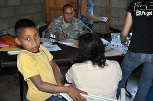 LA CEIBA, Honduras - Army Spc. Braulio Betanccourt listens to a woman in Spanish and writes down her answers in English during a medical training and readiness exercises here March 8. The Joint Task Force-Bravo medical team, along with Mission Honduras LeMars, the Honduran military, South Dakota State University nutritional team and Honduran Ministry of Health, saw more than 280 patients on day two of the four-day MEDRETE. (U.S. Air Force photo/Capt. Candice Allen)