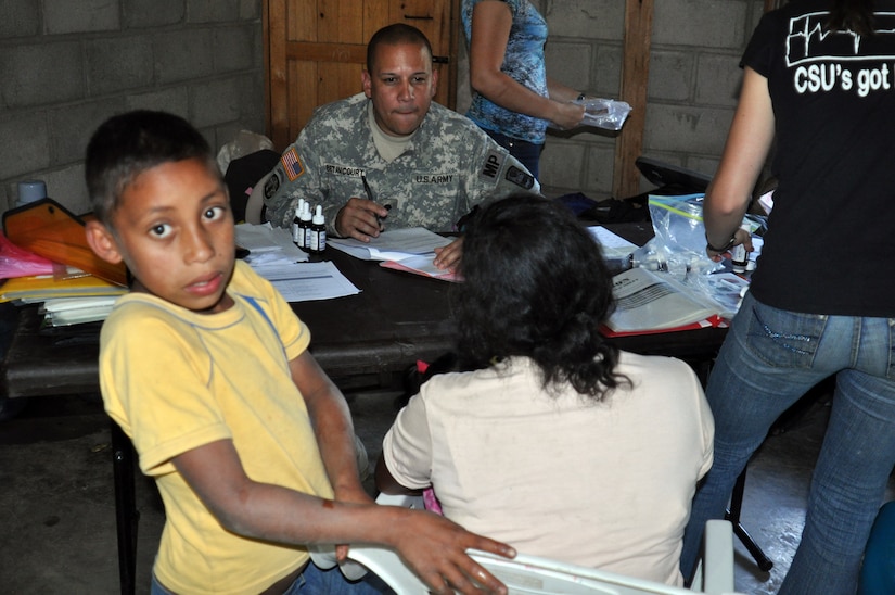 LA CEIBA, Honduras - Army Spc. Braulio Betanccourt listens to a woman in Spanish and writes down her answers in English during a medical training and readiness exercises here March 8. The Joint Task Force-Bravo medical team, along with Mission Honduras LeMars, the Honduran military, South Dakota State University nutritional team and Honduran Ministry of Health, saw more than 280 patients on day two of the four-day MEDRETE. (U.S. Air Force photo/Capt. Candice Allen)