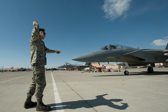 U.S. Air Force Staff Sgt.Matthew Shelburne, 142nd Fighter Wing, crew chief, Portland Air National Guard, marshals out an F-15C Eagle during Red Flag 12-3 March 8, 2012, at Nellis Air Force Base, Nev. Red Flag is a realistic combat training exercise involving the air forces of the United States and its allies. (U.S. Air Force photo by Staff Sgt. Christopher Hubenthal) 