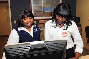 Victoria White, left, the General Smalls Inn reservation manager, assists Dashka Ezouard, a HIRED Program participant working as a desk clerk at the inn, with setting reservations at Fort Eustis, Va., March 6, 2012. The program was created to provide youths with workforce and secondary education training. (U.S. Air Force photo by Staff Sgt. Ashley Hawkins/Released)