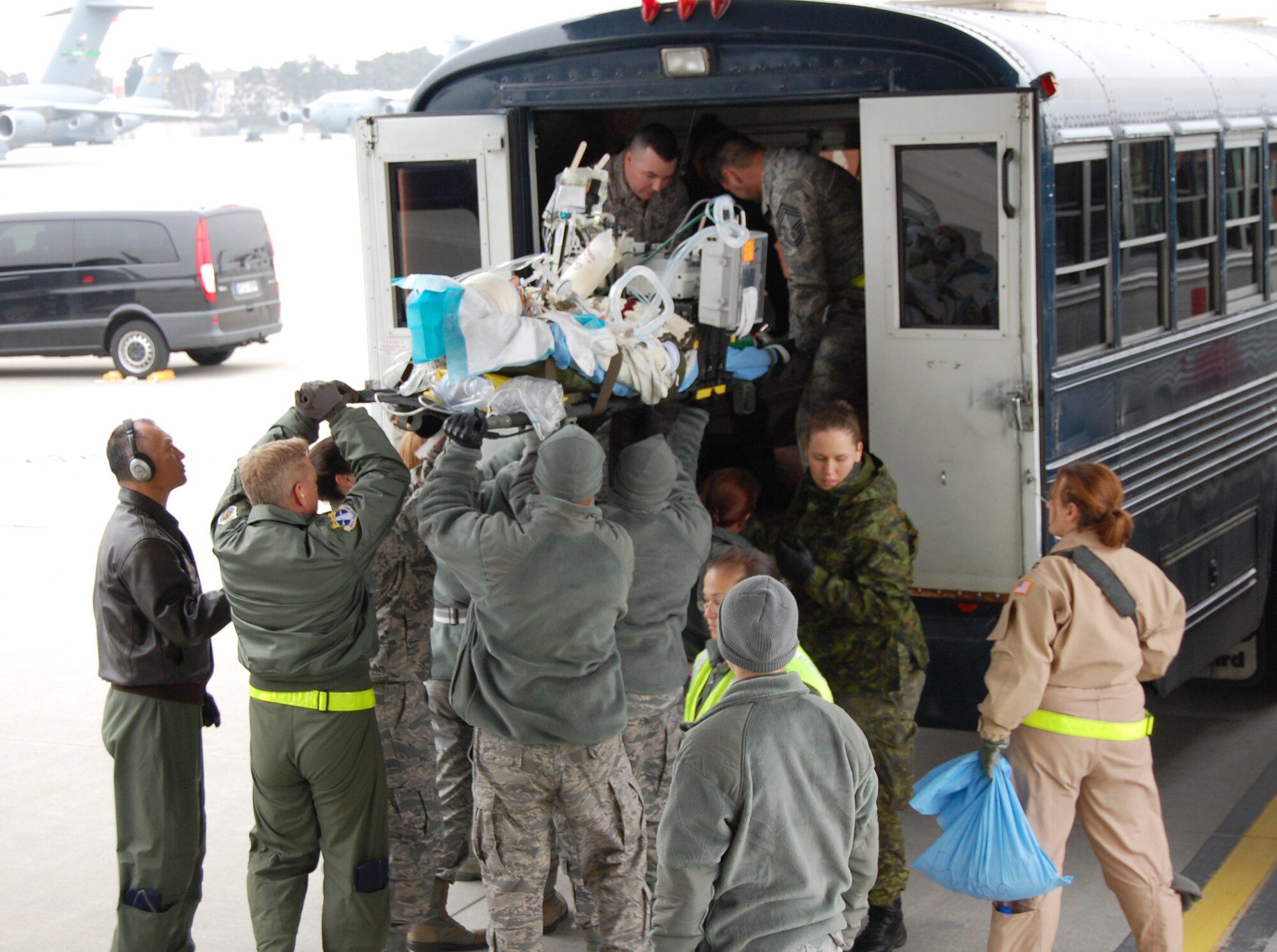 Col. Robert Ament, 920th Rescue Wing Vice Commander, Patrick Air Force Base, Fla., assists deployed medical Reservists from the 920th RQW lift a stretcher with a injured patient to get it on board a bus for transport at Ramstein Air Base. Leadership from the 920th RQW, recently visited these deployed medical Airmen in Germany to get a first-hand feel of their high tempo job. The members of the 920th Aeromedical Staging Squadron are consistently busy caring for the wounded warriors who come through their facility. Ramstein Air Base is the first stop for many of the wounded right off the battle field. (U.S. Air Force photo/Col. (Dr.) Richard Huot)