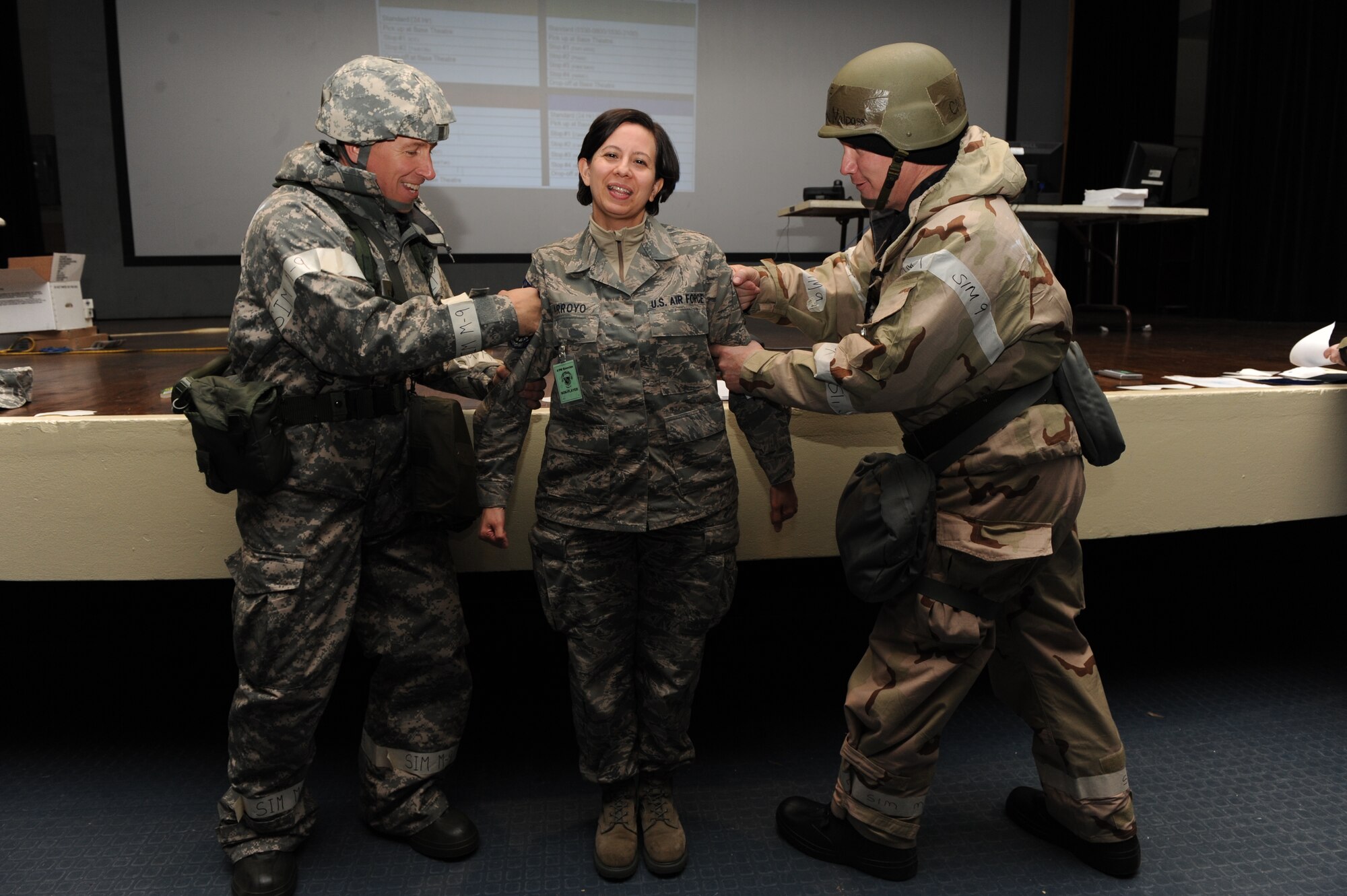 Col. Patrick Doherty and Chief Master Sgt. Blake Malpass tack on Master Sgt. Melissa Arroyo's senior master sergeant stripes during exercise Coronet Warrior 20-12 at Seymour Johnson Air Force Base, N.C. Arroyo, 4th Fighter Wing superintendent of knowledge operations management, was one of 18 Airmen from the wing selected for promotion to senior master sergeant. Doherty is the 4th FW commander and Malpass is the 4th FW command chief. (U.S. Air Force photo/Staff Sgt. Courtney Richardson/Released)