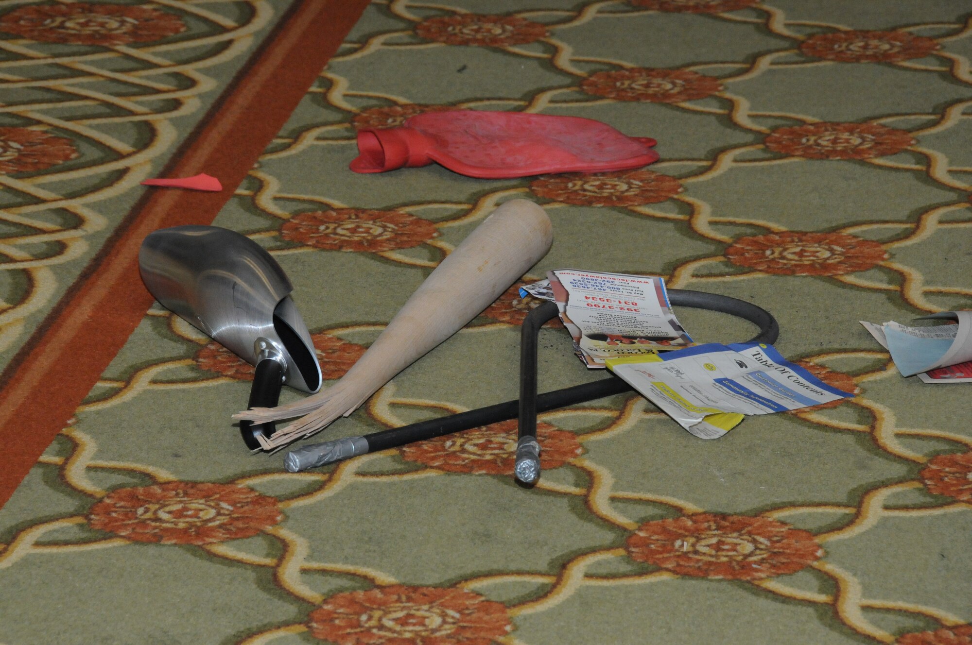 Broken wooden bats, bent metal rods, busted hot water bags, rolled metal frying pans and torn phone books lie on the floor after demonstrations by Team Impact members during  the team’s performance at Keesler’s National Prayer Breakfast ceremony March 6, 2012, at the Bay Breeze Event Center, Keesler Air Force Base, Miss.  Team Impact performs feats that require incredible strength to raise spiritual and physical awareness..  (U.S. Air Force photo by Kemberly Groue)