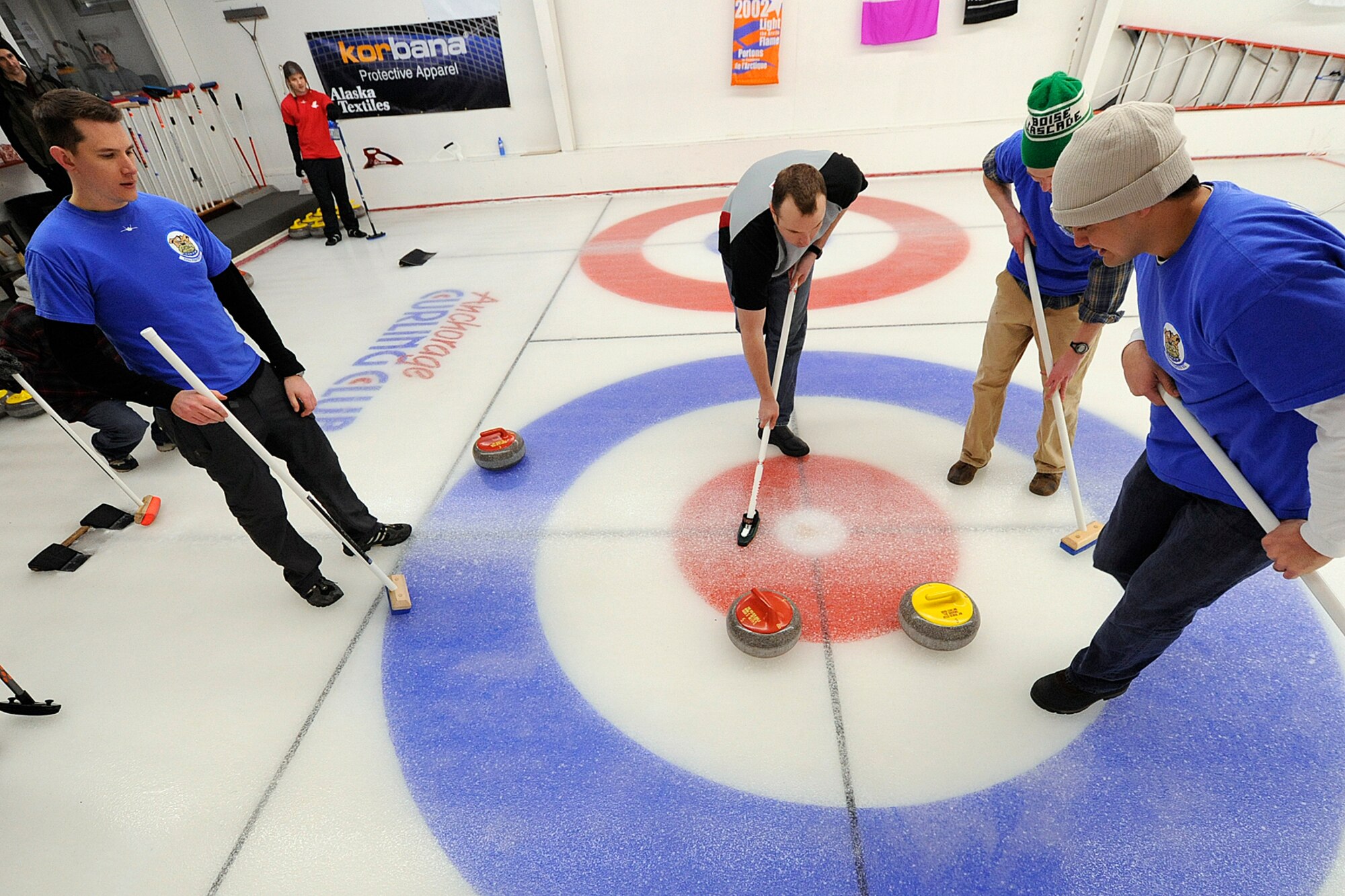 Curlers from the 962nd AACS and the 525th Fighter Squadron (blue shirts) vie for position of their teams' stones during the championship game of the 3rd Wing curling competition March 2 at the Anchorage Curling Club. All eight 3rd Wing squadrons provided five-person teams to take part in the friendly competition. The winning team came from the Royal Canadian Air Force contingent of the 962nd AACS. (U.S. Air Force photo/John Pennell)