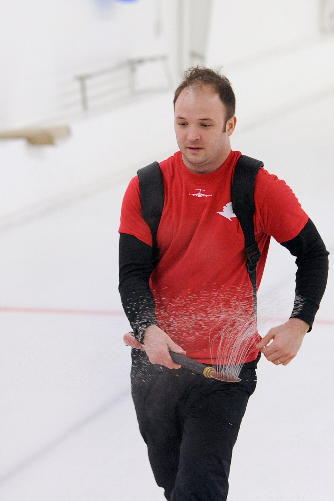 Capt. Zachary Dorman, 517th Airlift Squadron, works of the ice between curling games at the Anchorage Curling Club March 2. Dorman coordinated the 3rd Wing curling competition. (U.S. Air Force photo/John Pennell)