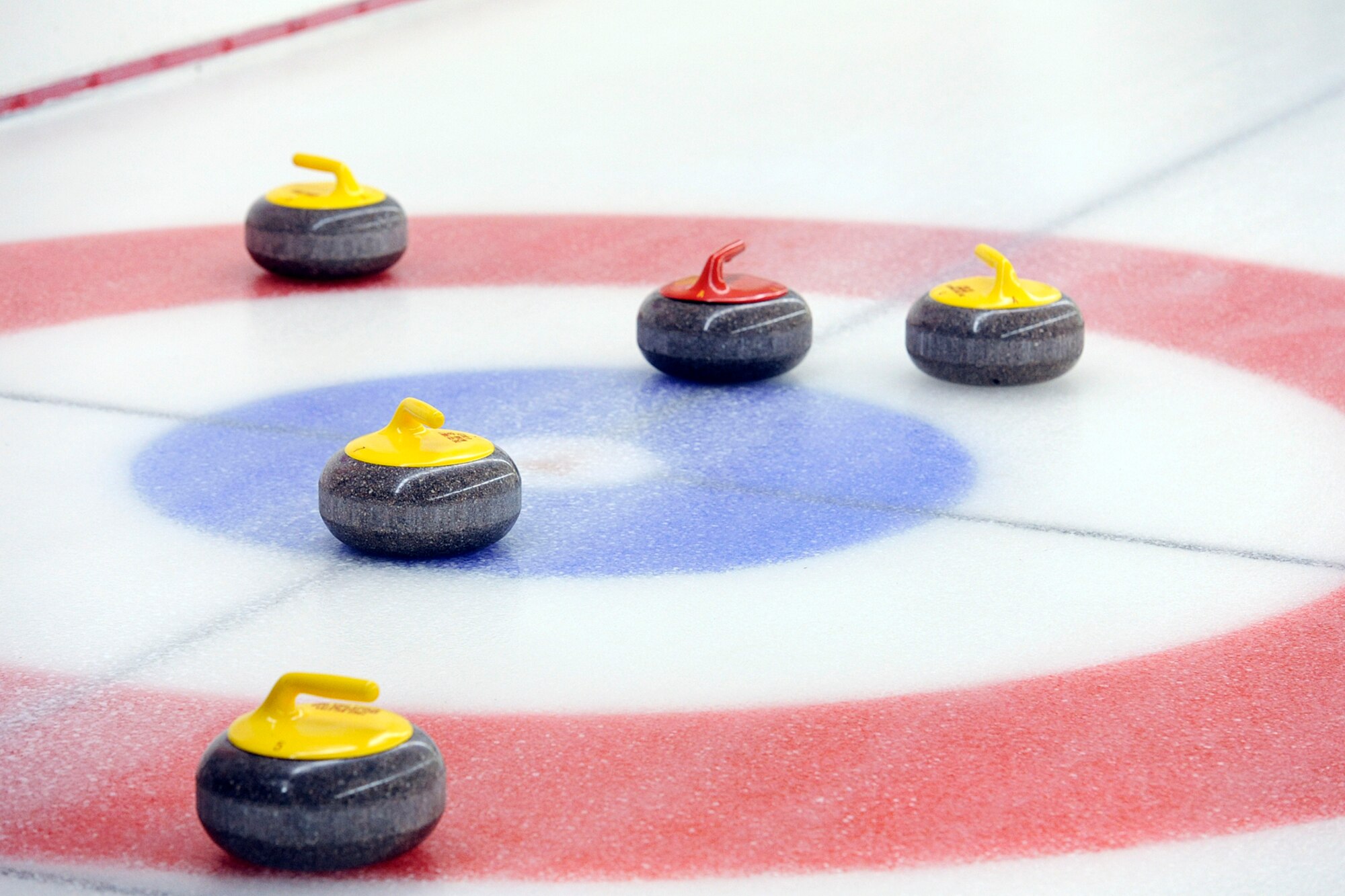 Curling stones rest on target during the 3rd Wing curling competition March 2 at the Anchorage Curling Club. (U.S. Air Force photo/John Pennell)