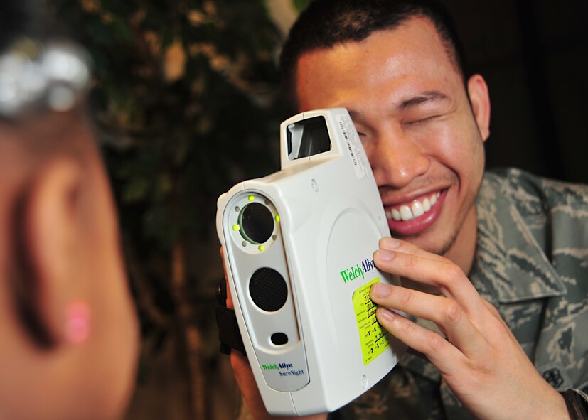 Senior Airman Jacinto Flores, 22nd Aerospace Medicine Squadron ophthalmic technician, administers an autorefraction test to a Team McConnell family member at the Child Development Center March 7, 2012 McConnell Air Force Base, Kan. The team conducted simple tests on visual acuity, color vision, depth perception, and verified that eye muscles were working properly. (U.S. Air Force photo/Staff Sgt. Maria A. Ruiz) 