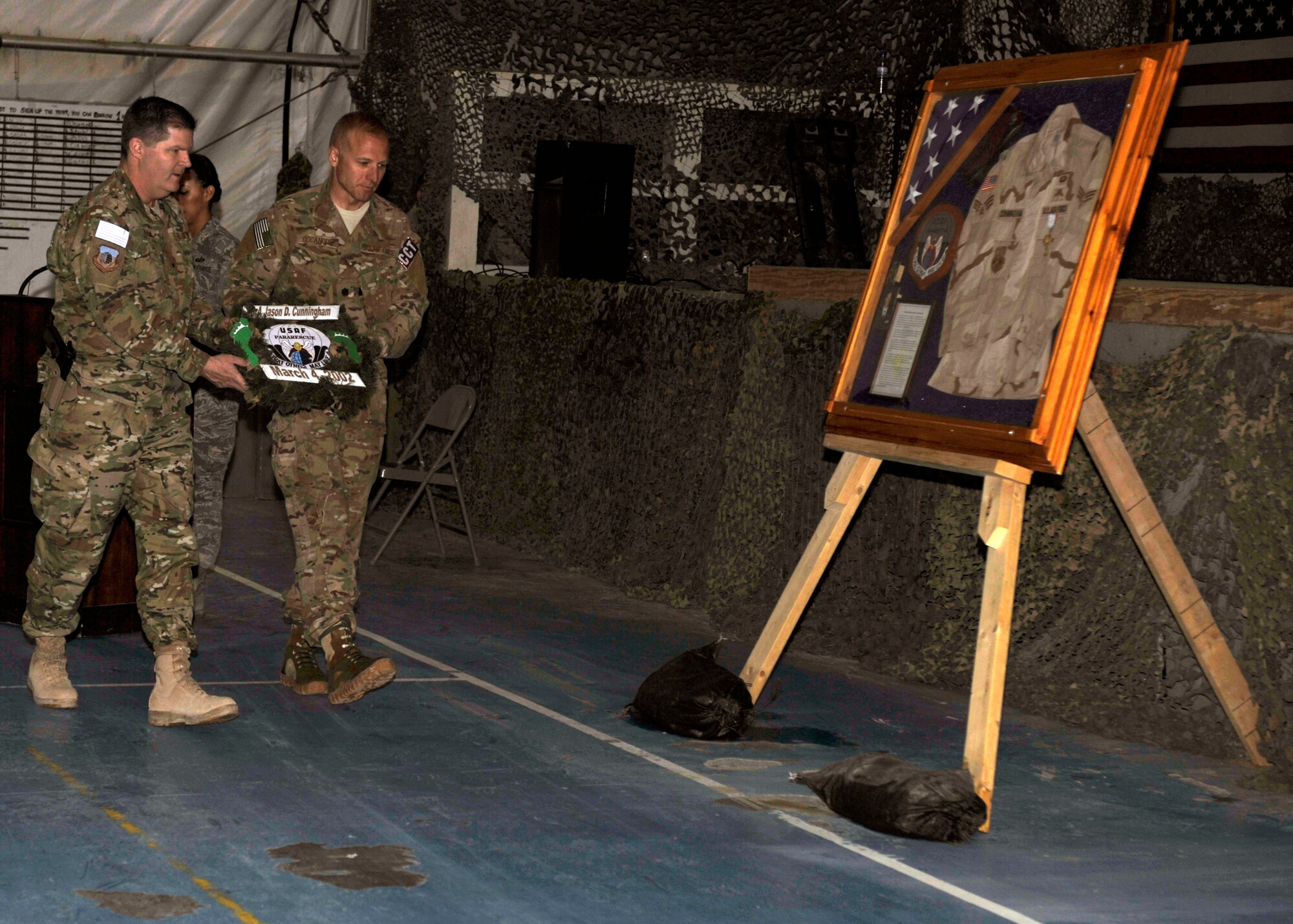 Brig. Gen. Thomas Deale (left) and Lt. Col. Spencer Cocanour walk to place an honorary wreath against the shadow box commemorating Senior Airman Jason Cunningham at Bagram Airfield, Afghanistan, March 4, 2012. Cocanour is the commander of the 21st Expeditionary Special Tactics Squadron and Deale is the commander of the 455th Air Expeditionary Wing. Cunningham was a pararescueman who died in combat March 4, 2002, while providing medical treatment under fire, saving 10 men’s lives. (U.S. Air Force photo/Airman 1st Class Ericka Engblom)