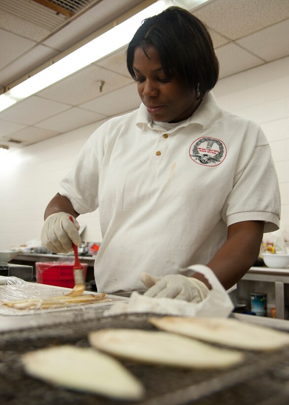 U.S. Army Specialist Cherice Nicholas, 1099th 7th Sustainment Brigade chef, glazes sliced pieces of eggplant for the Joint Base Langley-Eustis culinary team’s cold food display at the Food Services Training Center, Fort Lee, Va., during the 37th Annual Military Culinary Arts Competition, Mar. 5, 2012. Specialist Nicholas dish won the bronze medal in the B-3 category of the competition.  (U.S. Air Force photo by Senior Airman John D. Strong II/Released)