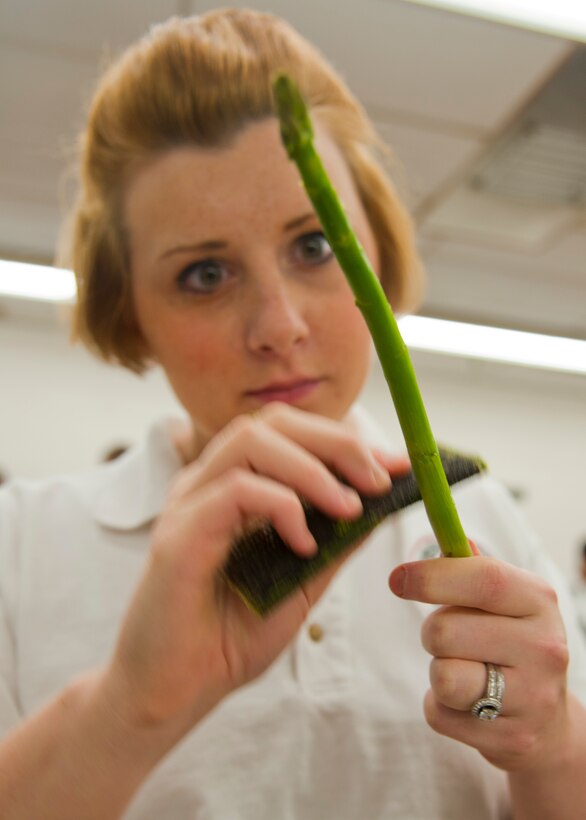 U.S. Air Force Senior Airman Julie Letner, 633rd Force Support Squadron chef, shaves down asparagus for the Joint Base Langley-Eustis culinary team during the 37th Annual Military Culinary Arts competition, Mar. 5, 2012. Airman Letner won the gold medal in the SK-9 category of the competition. (U.S. Air Force photo by Senior Airman John D. Strong II/Released)