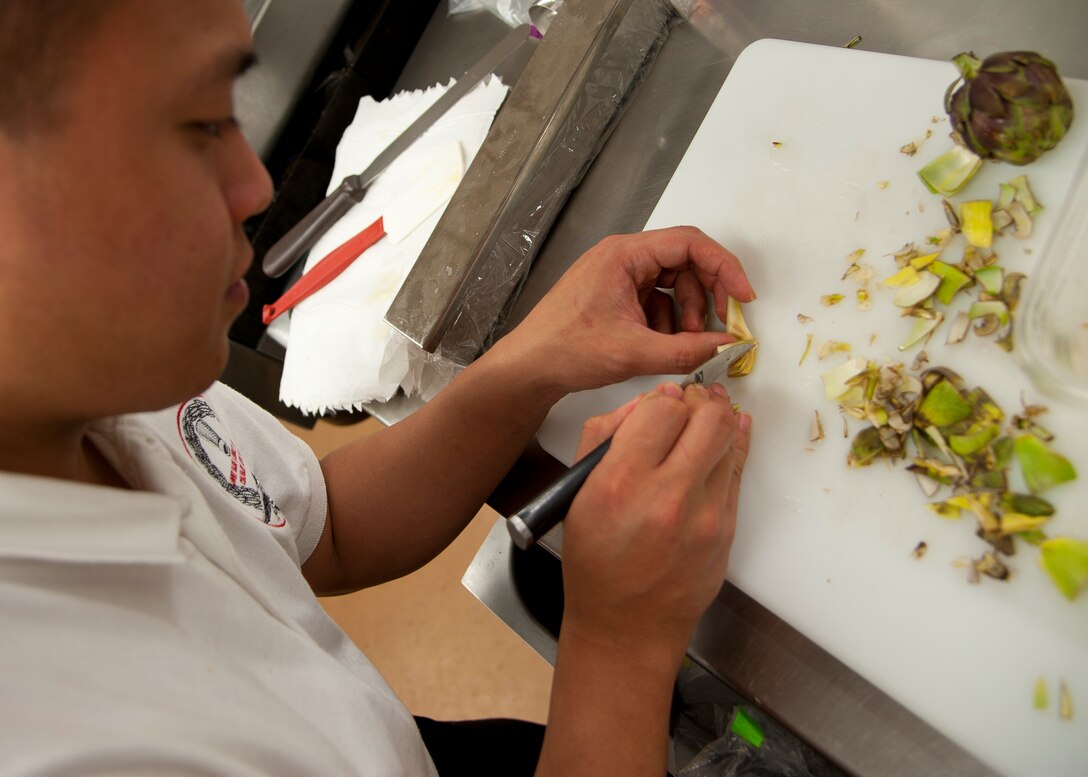 U.S. Air Force Staff Sgt. Ghil Medina, 633rd Force Support Squadron chef, slices artichokes for the Joint Base Langley-Eustis culinary team during the 37th Annual Military Culinary Arts Competition, Mar. 5, 2012. Sergeant Medina won the silver medal in the K-1 division, and bronze in both the F-1 and A-3 categories of the competition. (U.S. Air Force photo by Senior Airman John D. Strong II/Released)