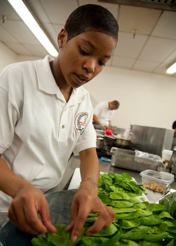 U.S. Air Force Senior Airman Dara Alexander, 633rd Force Support Squadron chef, separates spinach for the Joint Base Langley-Eustis culinary team’s cold food display at the Food Services Training Center, Fort Lee, Va., during the 37th Annual Military Culinary Arts Competition, Mar. 5, 2012,. Airman Alexander won the gold medal in the B-3 division of the competition. (U.S. Air Force photo by Senior Airman John D. Strong II/Released)