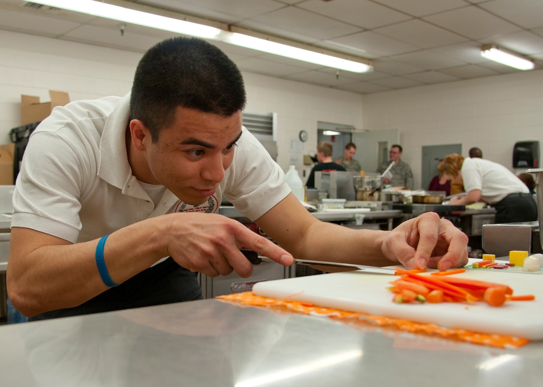 U.S. Air Force Staff Sgt. Kenny Archiles, 633rd Force Support Squadron chef, slices carrots for the cold food display at the Food Services Training Center, Fort Lee, Va., during the 37th Annual Military Culinary Arts Competition, Mar. 5, 2012. Sergeant Arciles won gold in the SK-9 division of the competition.  (U.S. Air Force photo by Senior Airman John D. Strong II/Released)
