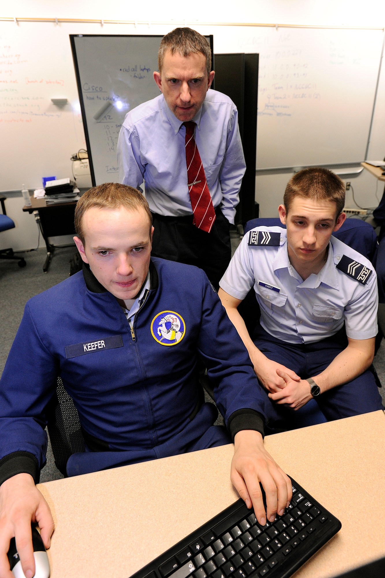 Cadet 1st Class Jordan Keefer (bottom left) and Cadet 2nd Class Nathan Hart (bottom right) work in the Air Force Academy's cyberwarfare laboratory March 5, 2012. Keefer and Hart are two of the eight cadets in the Academy's cyberwarfare team, which won a regional competition in Denver March 2-3. Also pictured is Dr. Martin Carlisle, the professor and academics deputy director for the Academy's Computer Science Department. (U.S. Air Force photo/Mike Kaplan)