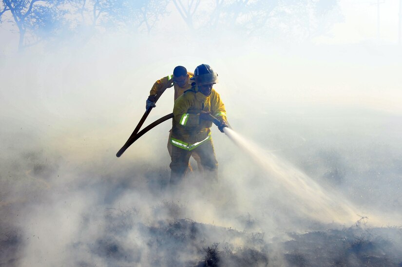 SOTO CANO AB, Honduras - Firefighters from the Comayagua Fire Department work to contain a brushfire on the south end of the flightline on Soto Cano AB March 4 here. The brushfire, which started when an electrical line fell due to high winds, was extinguished with the combined efforts of the Joint Task Force-Bravo Fire Department, Comayagua Fire Department and the 228th. (U.S. Air Force photo/Staff Sgt. Bryan Franks)