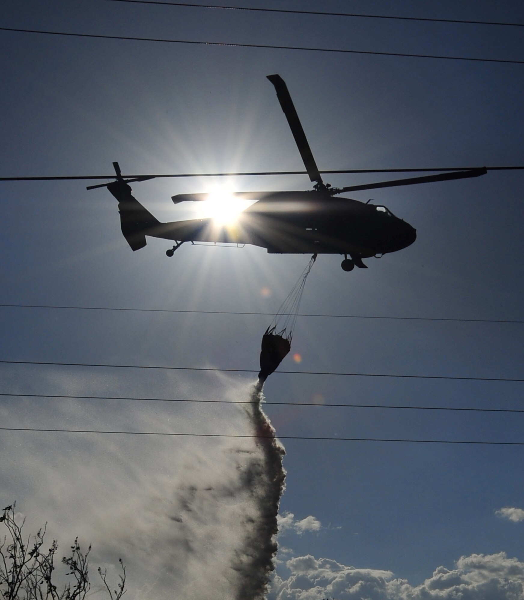 SOTO CANO AB, Honduras - A U.S. Army UH-60 Blackhawk assigned to 1st Battalion, 228th Aviation Regiment drops water on a brushfire 50 meters outside the perimeter of Soto Cano AB March 4 here. The brushfire, which started when an electrical line fell due to high winds, was extinguished with the combined efforts of the Joint Task Force-Bravo Fire Department, Comayagua Fire Department and the 228th. (U.S. Air Force photo/Staff Sgt. Bryan Franks) 