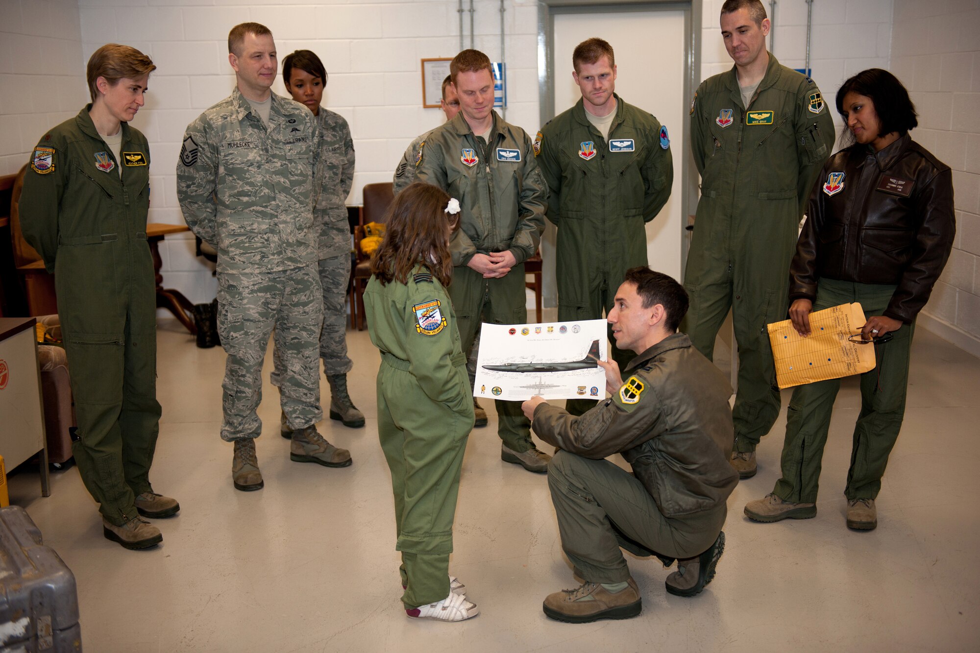 RAF FAIRFORD, United Kingdom -- Capt. Ray Tierney, 99th Reconnaissance Squadron U-2 pilot, presents Ellie Carter, a 9-year-old British schoolgirl, with a U-2 lithograph signed by current and former Dragon Lady pilots. Tierney presented the lithograph because of Ellie’s intense knowledge and passion for the U-2. (U.S. Air Force photo by Capt. Brian Maguire)