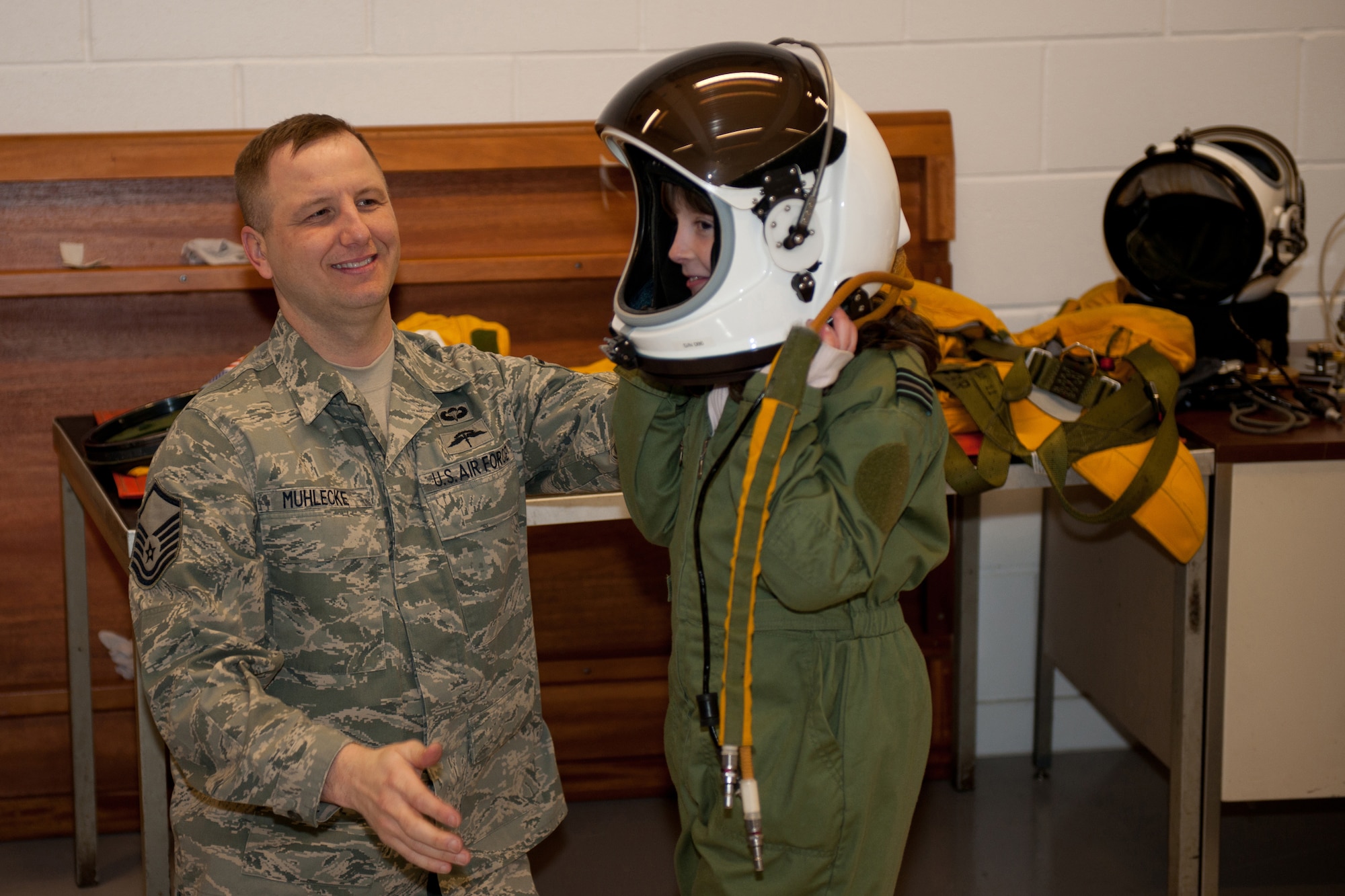 RAF FAIRFORD, United Kingdom -- Master Sgt. Carl Muhlecke, 9th Physiological Support Squadron, places the pilot’s helmet on Ellie Carter at RAF Fairford. The helmet is part of the full pressure suit a U-2 pilot must wear, and is similar to the suits worn by astronauts. (U.S. Air Force photo by Capt. Brian Maguire)