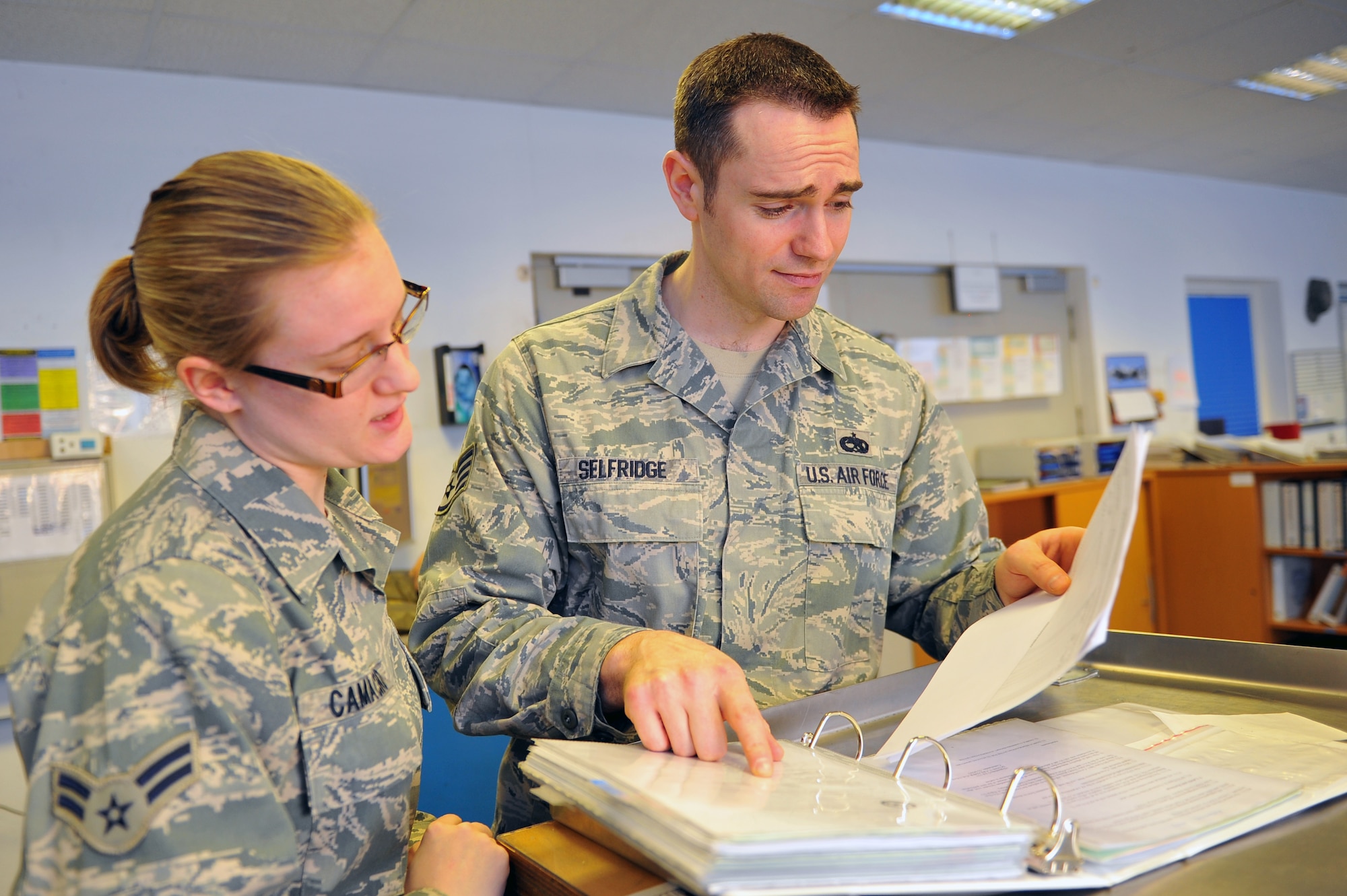 SPANGDAHLEM AIR BASE, Germany – Staff Sgt. Michael Selfridge, right, 52nd Maintenance Operations Squadron aircraft maintenance inspector, checks work programs with Airman 1st Class Katelyn Camacho, 52nd Equipment Maintenance Squadron phase support section member, during an inspection inside Bldg. 346 here March 8. The AMXS quality assurance section is made up of eight certified maintenance inspectors who inspect 81st and 480th Fighter Squadron aircraft maintenance processes. Quality assurance modernizes the Air Force’s aircraft and equipment maintenance and training by tracking maintenance performance against metrics to improve efficiency, production, and reliability.  (U.S. Air Force photo by Airman 1st Class Dillon Davis/Released)