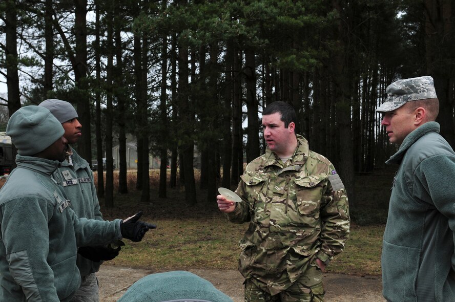 STANFORD TRAINING AREA, England – Cpl. Craig Paterson (right center), 15 Squadron, Royal Air Force Regiment, paramedic, speaks to members of the 820th Base Defense Squadron during pre-deployment training Feb. 27.  Members of the 820th BDS, stationed at Moody Air Force Base, Ga., trained with Regiment personnel to increase interoperability while deployed in joint environments. (U.S. Air Force photo by Airman 1st Class Cory D. Payne) (Released)
 
