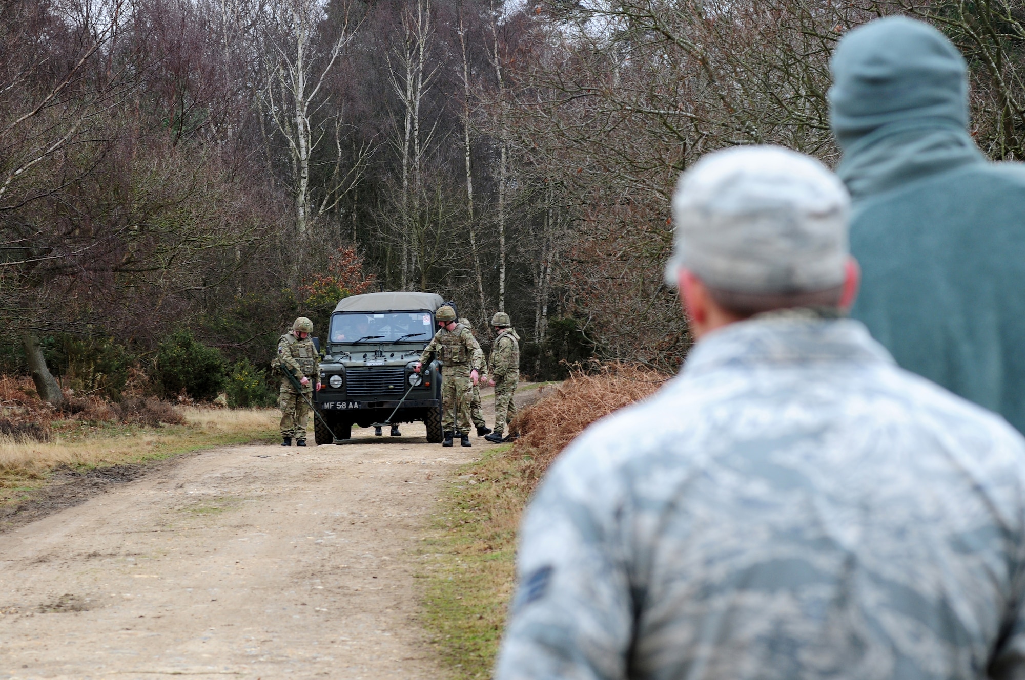 STANFORD TRAINING AREA, England – Members of the 820th Base Defense Squadron observe Regiment personnel utilize metal detectors when conducting counter improvised explosive device counter measures Feb. 27. The 820th BDS, from Moody Air Force Base, Ga., trained with Regiment personnel to increase interoperability while deployed in joint environments. (U.S. Air Force photo by Airman 1st Class Cory D. Payne) (Released)