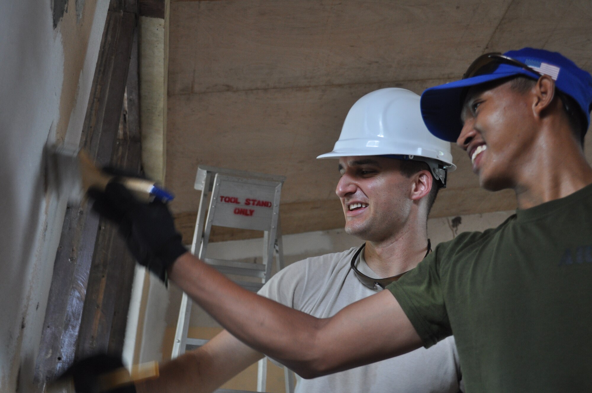 2nd Lt. Benjamin Shearer, 36th Civil Engineer Squadron flight chief resource management and Philippine Army Private 1st Class Jaypy Lagua (forefront), welder and mason, share a laugh on March 5, 2012, while they paint Binitayan Elementary School, Legazpi City, Philippines during Operation Pacific Angel-Philippines. PACANGEL is a joint and humanitarian operation. It is scheduled to run through March 10. (U.S. Air Force photo/Master Sgt. Allison Day)

