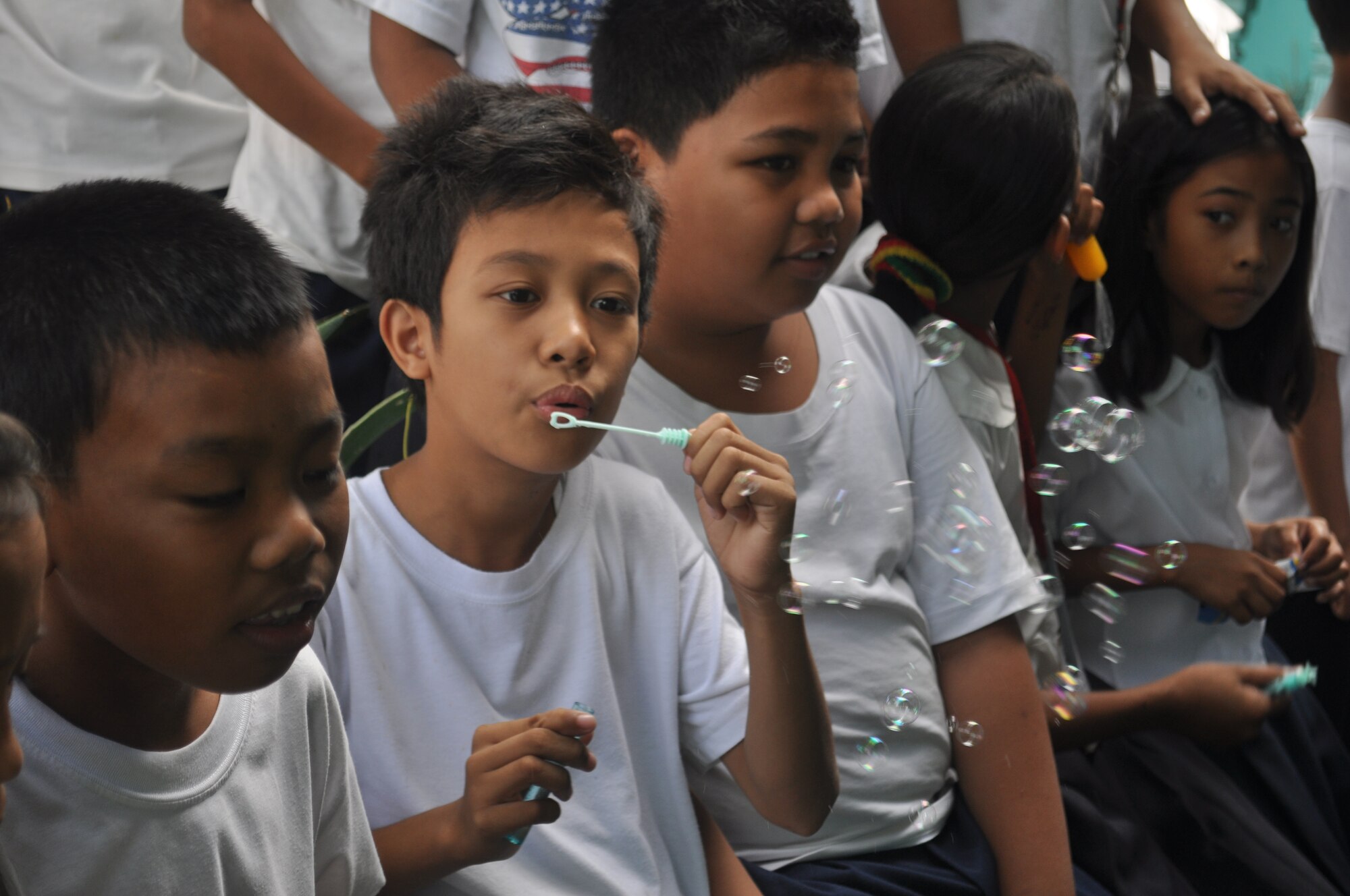Angelo, a student at the school, blows bubbles given to him by Senior Airman James Peterson, 36th Civil Engineer Squadron utilities journeyman, from Andersen Air Force Base, Guam, on March 5, 2012. Angelo and his friends kept an eye during recess while the U.S. and Philippine military forces worked on their school, Binitayan Elementary School, Legazpi City, Philippines. Operation Pacific Angel-Philippines is a joint and humanitarian mission and includes engineering support in the region. The school is one of three engineering projects supported during PACANGEL. PACANGEL is scheduled to run through March 10. (U.S. Air Force photo/Master Sgt. Allison Day)
