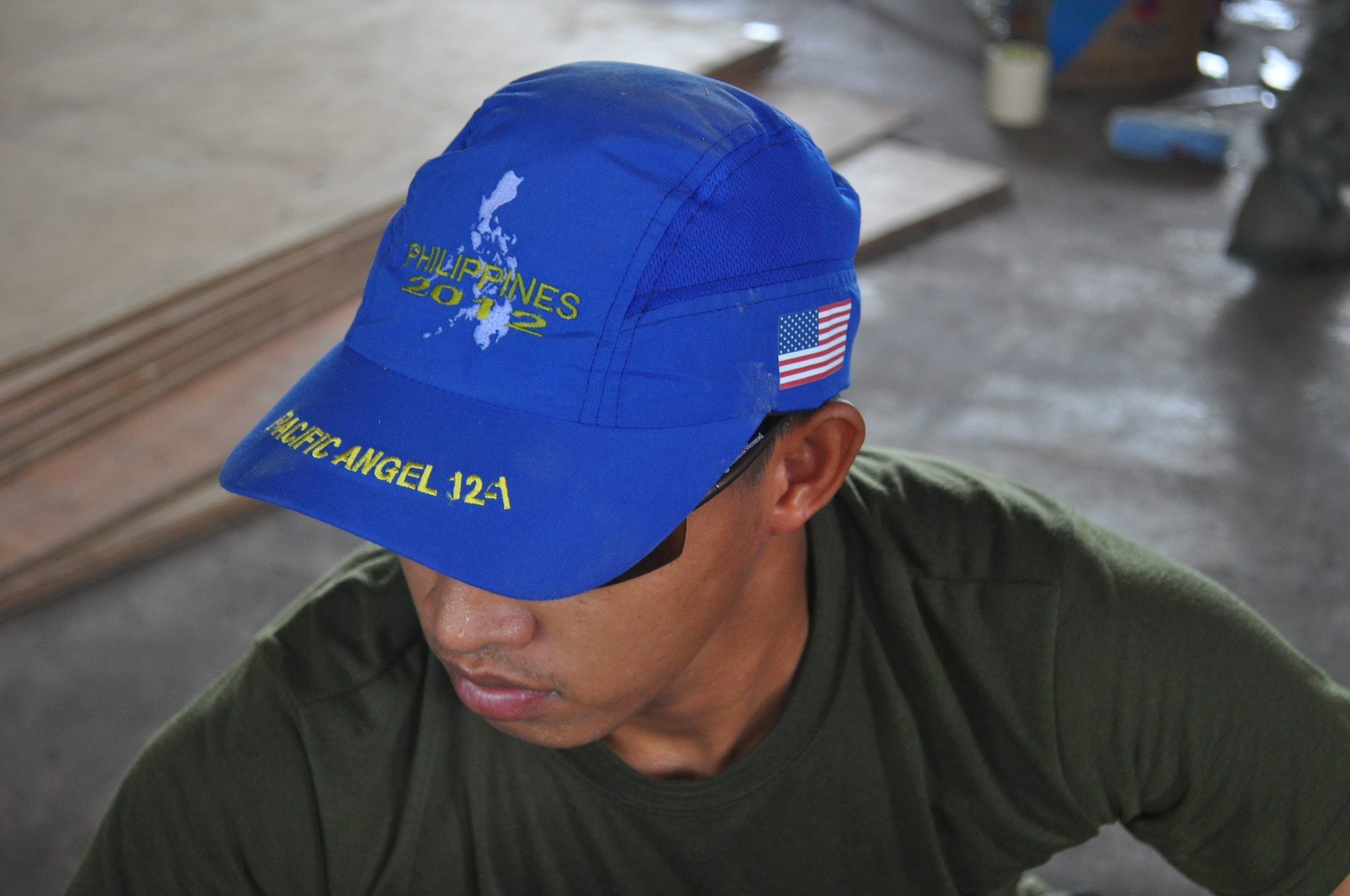 Philippine Army Private 1st Class Jaypy Lagua, welder and mason sports the official ball cap worn during Operation Pacific Angel-Philippines March 5, 2012 while he paints one of the classrooms at Binitayan Elementary School, Legazpi City here. Pacific Angel is a joint and combined humanitarian operation led by 13th Air Force. It is scheduled to run through March 10. (U.S. Air Force photo/Master Sgt. Allison Day)