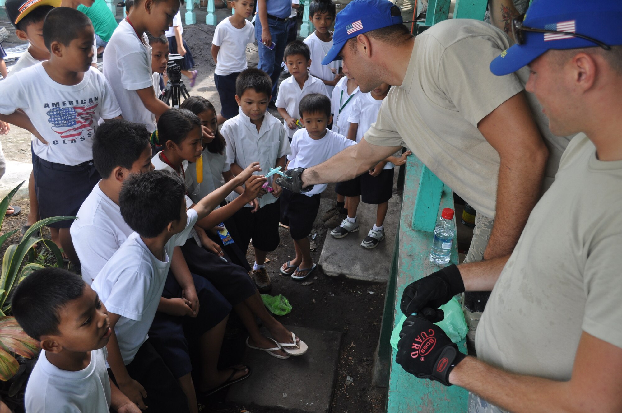 Senior Amn. James Peterson, 36th Civil Engineer Squadron utilities journeyman from Andersen Air Force Base, Guam, takes a few minutes to pass out bubbles to students at Binitayan Elementary School, Legazpi City, Philippines, March 5, 2012, during recess while Airman 1st Class Taylor Vondrasek, 36th CES structural apprentice, looks on. The students spent time at recess observing the engineers who were rebuilding three classrooms during Operation Pacific Angel-Philippines a joint and humanitarian mission which included engineering support to the region. It is scheduled to run through March 10. (U.S. Air Force photo/Master Sgt. Allison Day)
